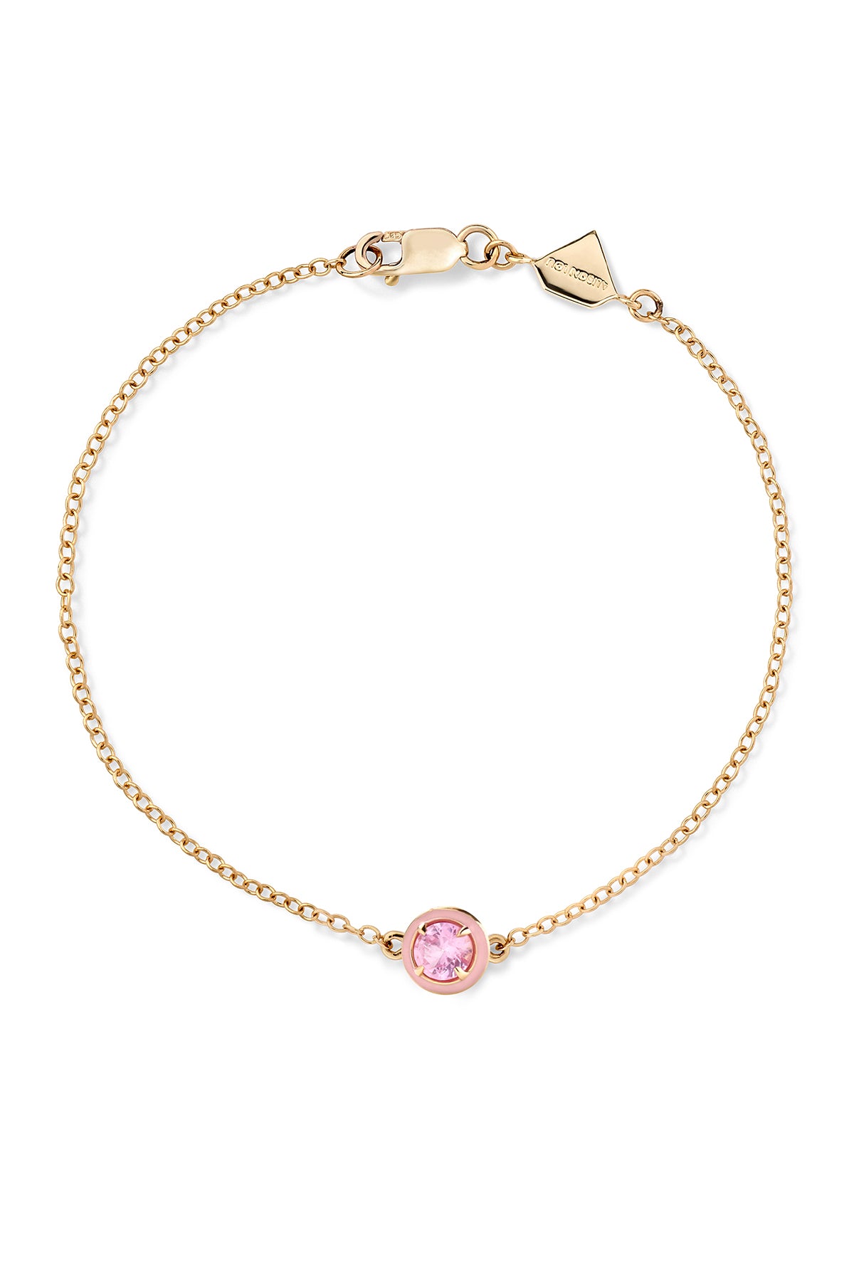 A gold bracelet with a single round lab-created pink gemstone and two-tone enamel.